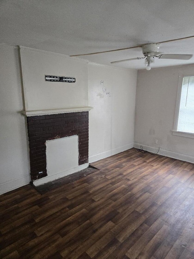 213 Whitehead St, Thomson, GA 30824 - unfurnished living room featuring ceiling fan, a brick fireplace, dark wood-style floors, and baseboards