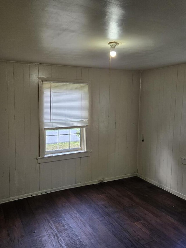 213 Whitehead St, Thomson, GA 30824 - unfurnished room featuring dark wood-style floors, wooden walls, and baseboards