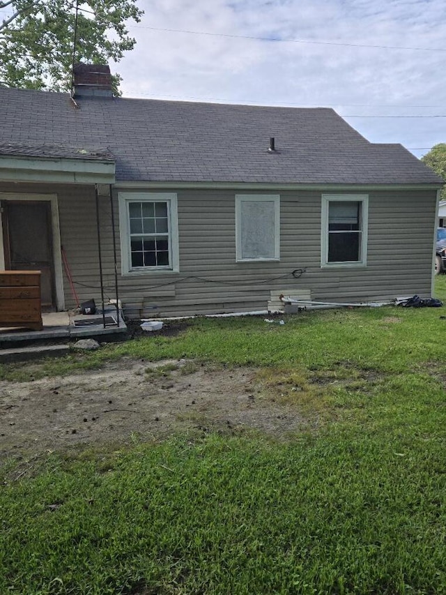 213 Whitehead St, Thomson, GA 30824 - rear view of house featuring a chimney, roof with shingles, and a lawn