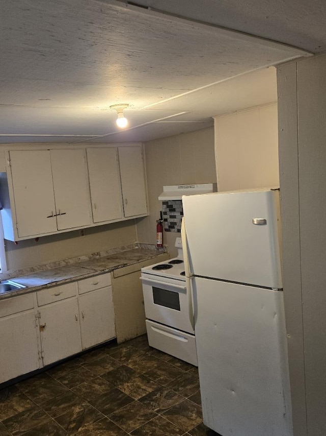 213 Whitehead St, Thomson, GA 30824 - kitchen featuring white appliances, white cabinetry, under cabinet range hood, a sink, and dark stone finish flooring