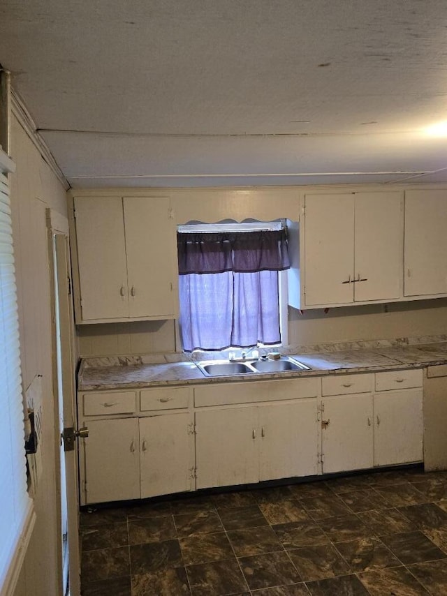 213 Whitehead St, Thomson, GA 30824 - kitchen with a sink, white cabinetry, stone finish floors, and light countertops