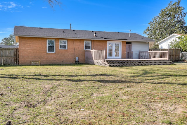 back of house featuring french doors, a lawn, fence, and brick siding