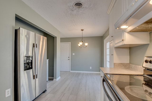 kitchen with stainless steel appliances, visible vents, light wood-style floors, a textured ceiling, and under cabinet range hood