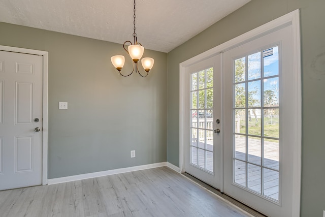 doorway with french doors, a healthy amount of sunlight, baseboards, and light wood finished floors