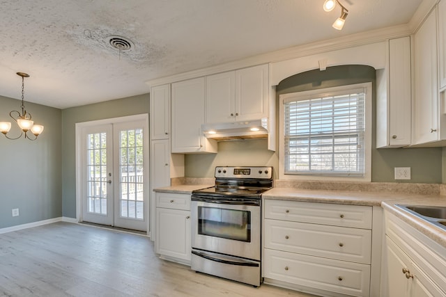 kitchen with a healthy amount of sunlight, stainless steel range with electric stovetop, under cabinet range hood, and visible vents