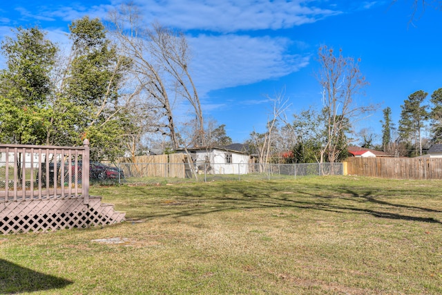 view of yard featuring fence and a deck