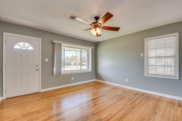 entrance foyer with a ceiling fan, light wood-style flooring, baseboards, and a textured ceiling