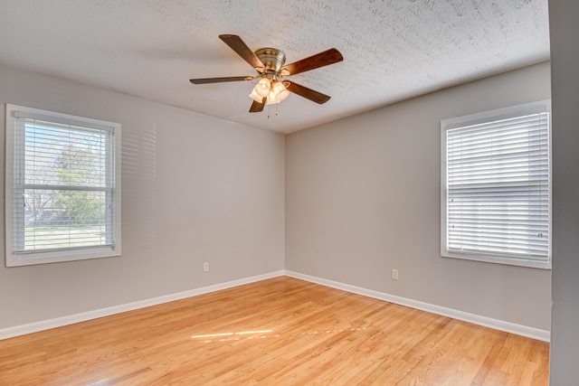 unfurnished room featuring baseboards, a textured ceiling, a ceiling fan, and light wood-style floors