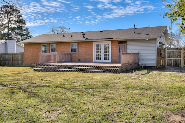 back of property featuring fence private yard, a wooden deck, a yard, and french doors