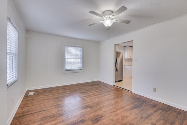 unfurnished room featuring ornamental molding, dark hardwood / wood-style floors, a textured ceiling, and ceiling fan