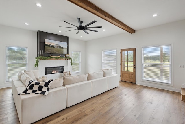 1513 Paris Ave, Swainsboro, GA 30401 - living area with healthy amount of natural light, a fireplace, beamed ceiling, a ceiling fan, and light wood-type flooring