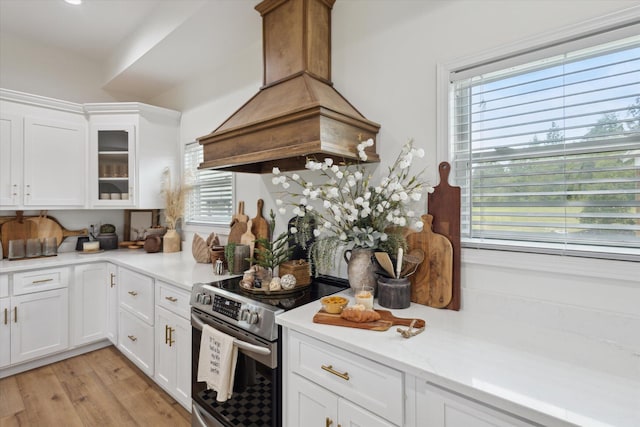 1513 Paris Ave, Swainsboro, GA 30401 - kitchen featuring electric stove, island range hood, light countertops, white cabinetry, and glass insert cabinets