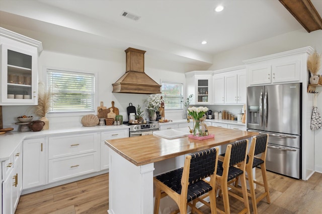 1513 Paris Ave, Swainsboro, GA 30401 - kitchen with appliances with stainless steel finishes, custom range hood, butcher block countertops, white cabinetry, and recessed lighting
