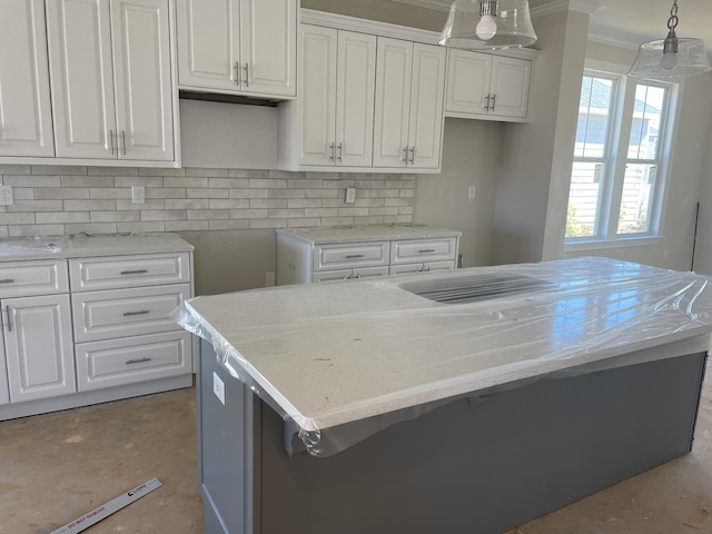 kitchen with hanging light fixtures, a kitchen island, and white cabinetry