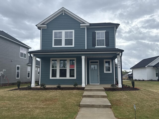 view of front of house featuring covered porch and a front yard