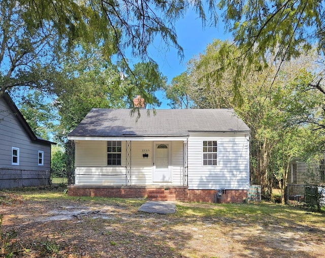 bungalow featuring covered porch and fence