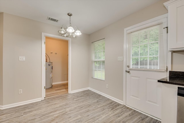 1907 Lobelia Ln, Augusta, GA 30906 - unfurnished dining area with water heater, light wood-style flooring, a chandelier, and baseboards