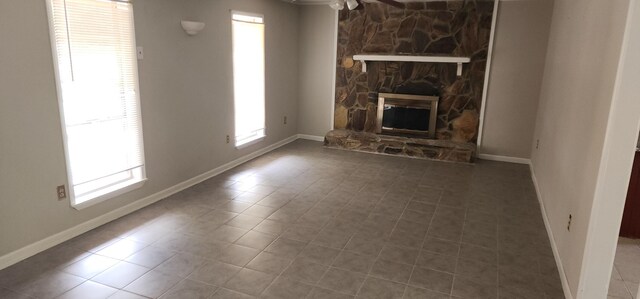 3545 Monte Carlo Dr, Augusta, GA 30906 - unfurnished living room with tile patterned floors, a ceiling fan, and a stone fireplace