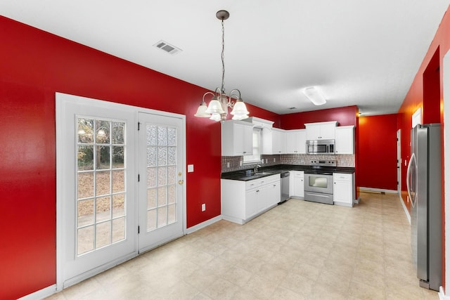 kitchen featuring white cabinets, stainless steel appliances, plenty of natural light, and pendant lighting