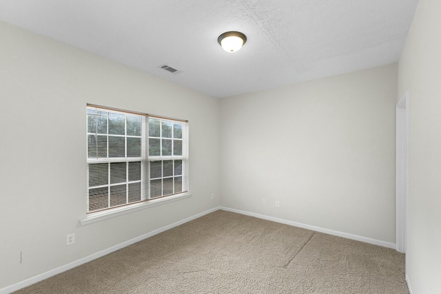 carpeted empty room with a textured ceiling