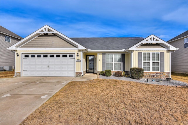 view of front of house with a front lawn, a garage, and central AC unit