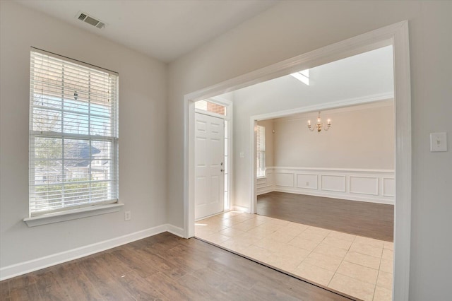 unfurnished room with wood-type flooring and a notable chandelier