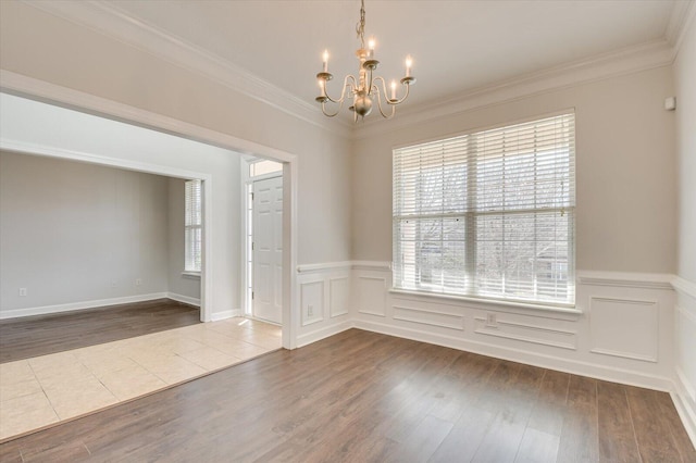 empty room with an inviting chandelier, crown molding, and hardwood / wood-style flooring