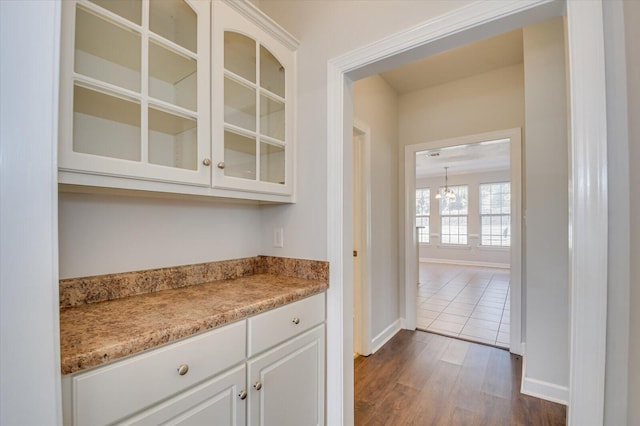 bar featuring dark hardwood / wood-style floors and white cabinetry