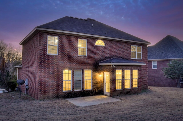 back house at dusk featuring a patio area