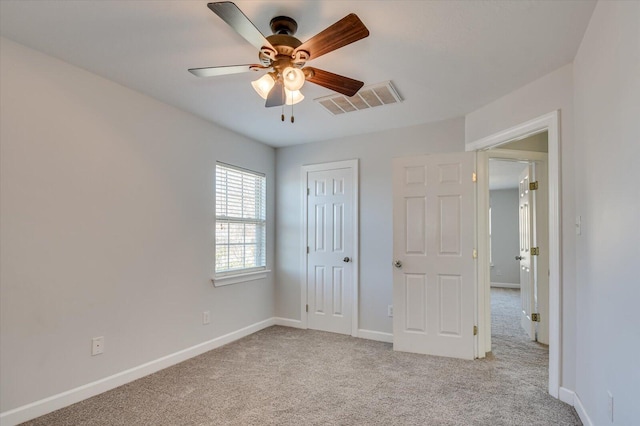 unfurnished bedroom featuring ceiling fan, light colored carpet, and a closet