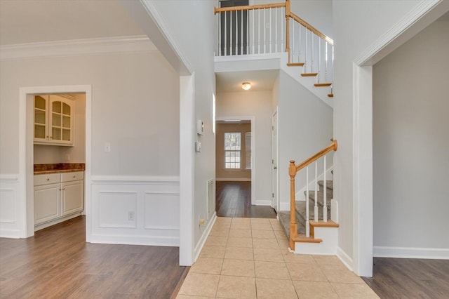 foyer entrance featuring ornamental molding and light hardwood / wood-style flooring