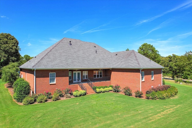 rear view of property featuring a lawn