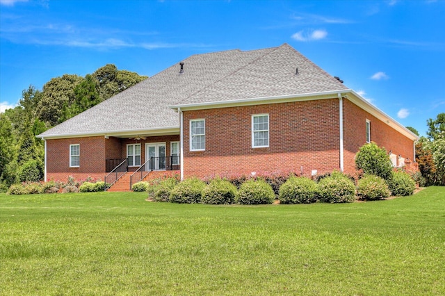 back of house with a lawn and ceiling fan