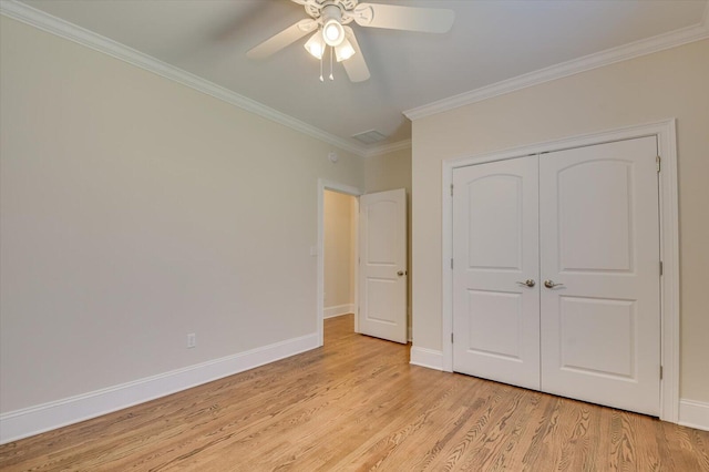 unfurnished bedroom featuring light wood-type flooring, a closet, ceiling fan, and crown molding