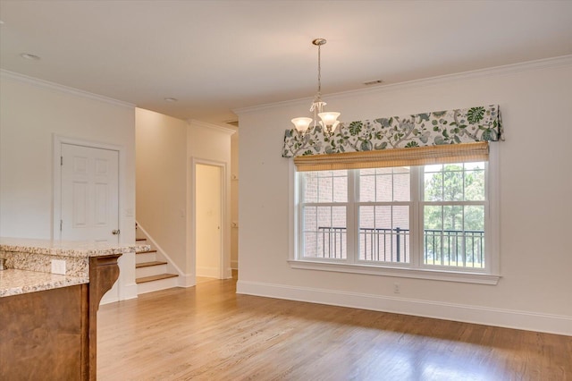 dining room with a chandelier, crown molding, and light hardwood / wood-style flooring