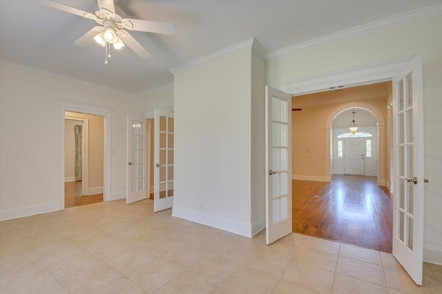 empty room featuring crown molding, french doors, light tile patterned floors, and ceiling fan