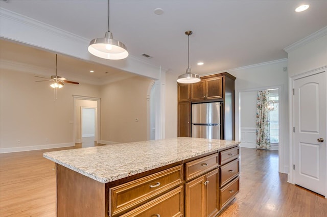 kitchen with ceiling fan, crown molding, pendant lighting, a center island, and stainless steel refrigerator