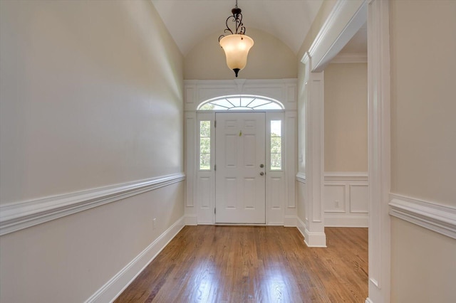 entrance foyer with wood-type flooring and vaulted ceiling