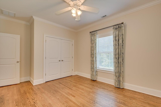 unfurnished bedroom with ceiling fan, a closet, light hardwood / wood-style flooring, and ornamental molding