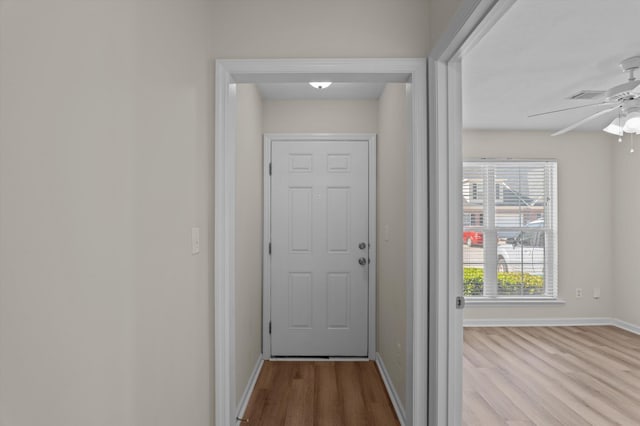 doorway to outside featuring visible vents, baseboards, a ceiling fan, and wood finished floors