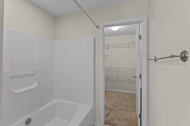 bathroom with a walk in closet and shower / bath combination