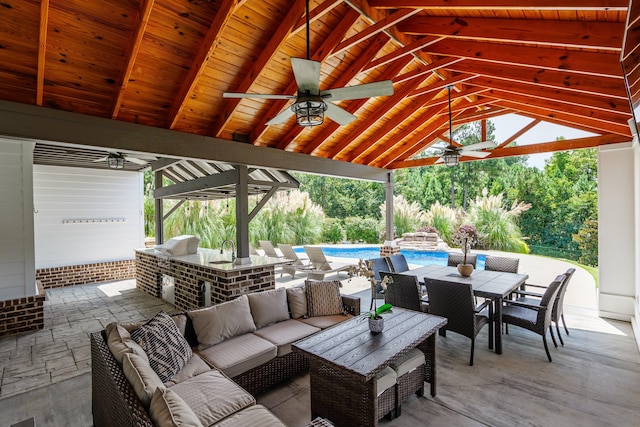 view of patio with an outdoor kitchen, a gazebo, ceiling fan, exterior bar, and an outdoor living space