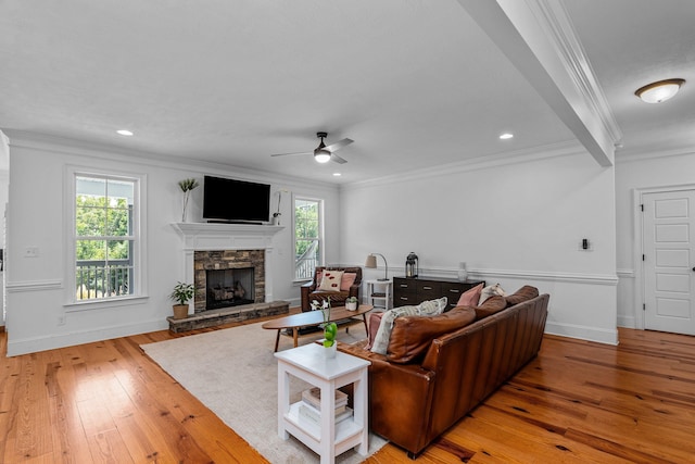 living room featuring a fireplace, ceiling fan, light hardwood / wood-style floors, and crown molding