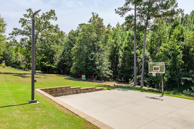 view of sport court with a lawn