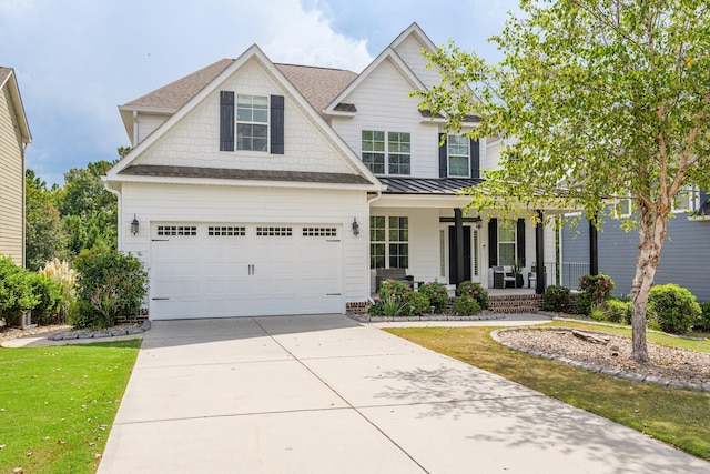 craftsman-style house featuring a garage, covered porch, and a front lawn