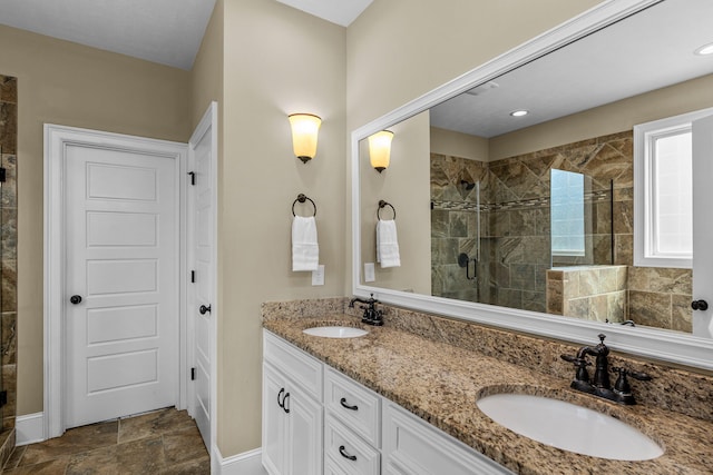 bathroom featuring a shower with door and vanity