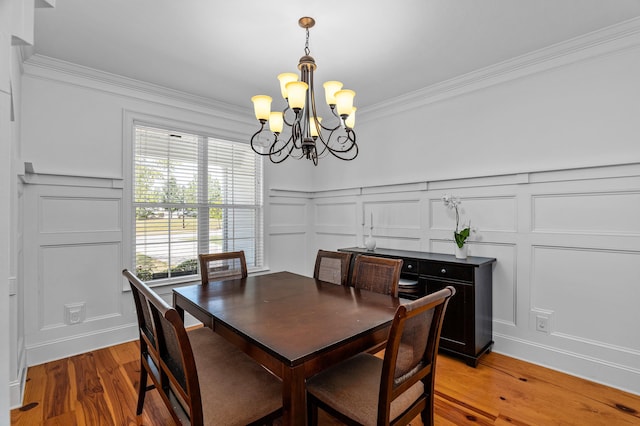 dining room featuring a notable chandelier, light wood-type flooring, and crown molding