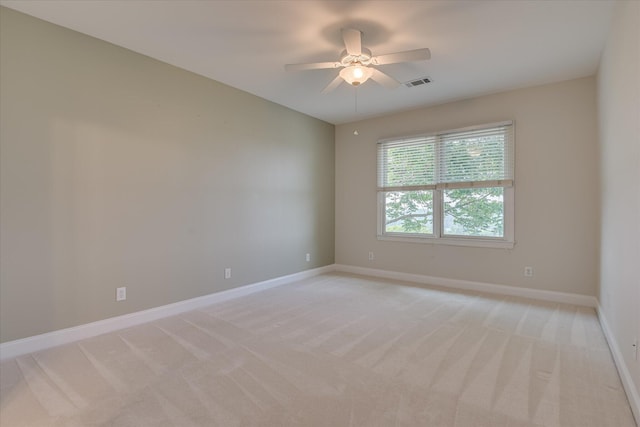 unfurnished room featuring light carpet, a ceiling fan, and baseboards