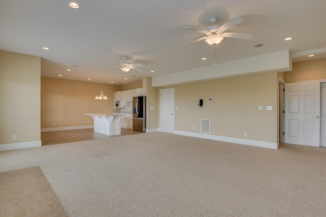 unfurnished living room featuring light colored carpet, ceiling fan, recessed lighting, and baseboards