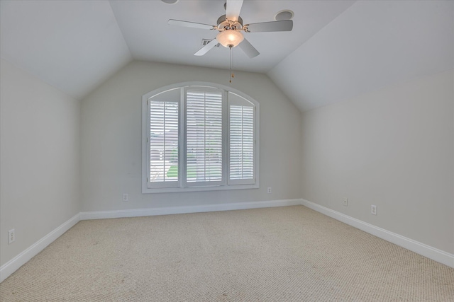 additional living space with lofted ceiling, light colored carpet, ceiling fan, and baseboards
